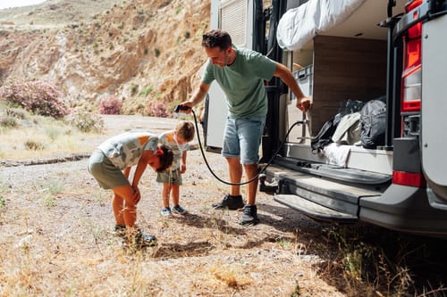 father-and-children-cooling-down-by-camper-van and rv plumbing